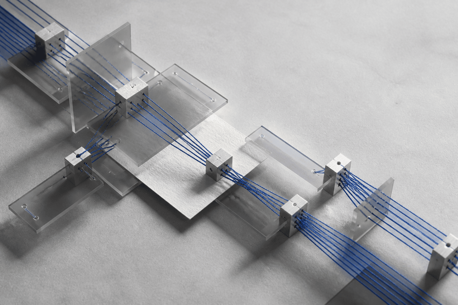 Abstract arrangement of blue threads passing through a structured system